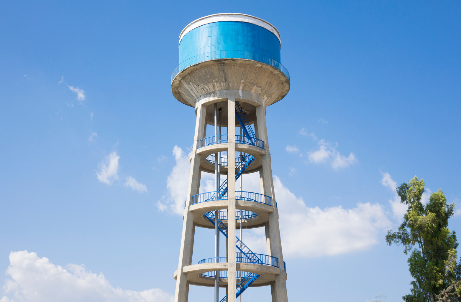 Water tower painted blue under blue sky